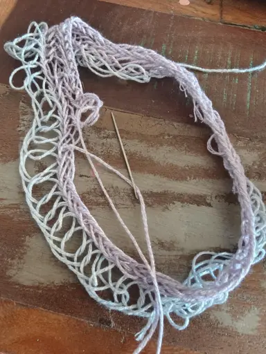 A project in nalbind, with two rows of made. The first row was in blue, with the knots not at all tight enough. The second row is in purple, and here the knots are tight.