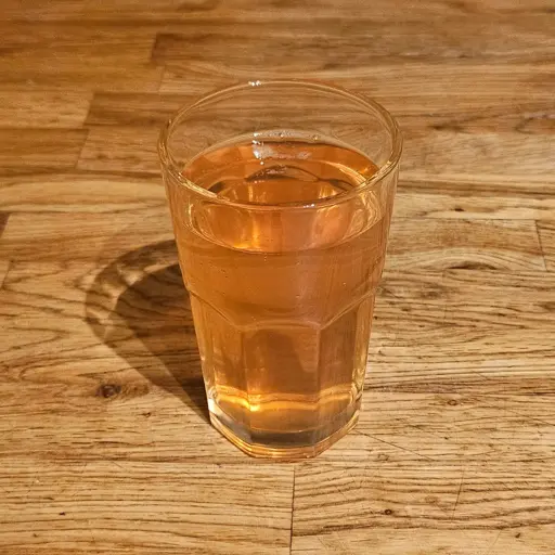 A glass of rowanberry juice. Light orange-pink in color