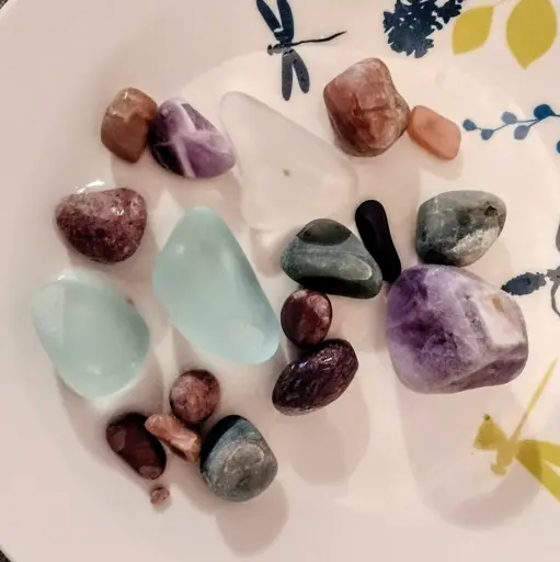 A handful of different partially smoothes rocks of different types and textures, on a dollar-store appetizer plate.