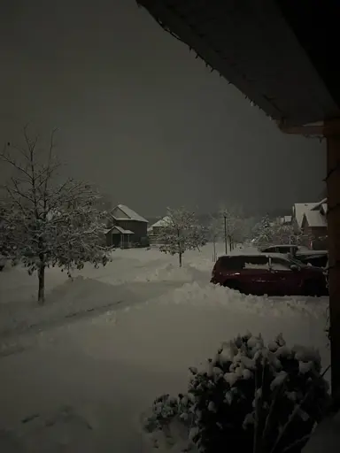 A deep layer of snow covers everything in a neighbourhood.
