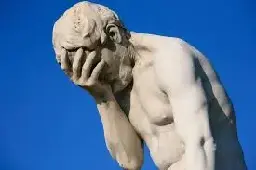 A facepalming statue of a man.