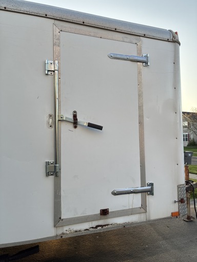 Side door of enclosed trailer showing new hinges, cam bar, and the door juice that squeezed out when tightening the bottom hinge.